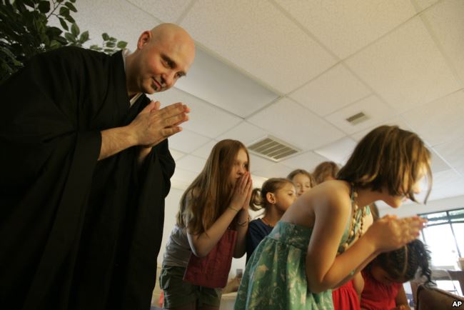 In this Sunday, June 19, 2011 photo, Rev. Jay Rinsen Weik bows with children after lighting an incense candle at the Toledo Zen Center in Holland, Ohio. The center has created a Sunday school and other programs to be especially welcoming to families. In this Sunday, June 19, 2011 photo, Rev. Jay Rinsen Weik bows with children after lighting an incense candle at the Toledo Zen Center in Holland, Ohio. The center has created a Sunday school and other programs to be especially welcoming to families.